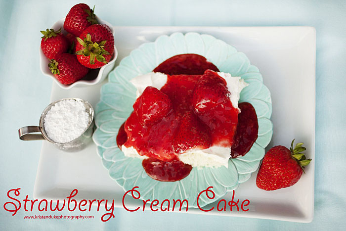 slice of strawberry cream cake topped with fresh strawberries